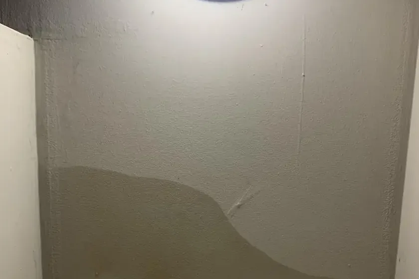 A roof leak stain running down a skylight well wall